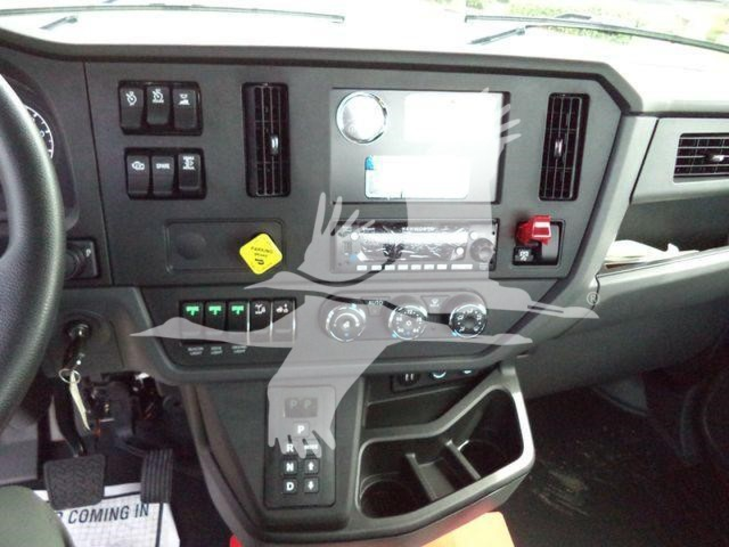 Kenworth T280 dashboard/center console showing controls, screen, gear shifter, and storage compartments.