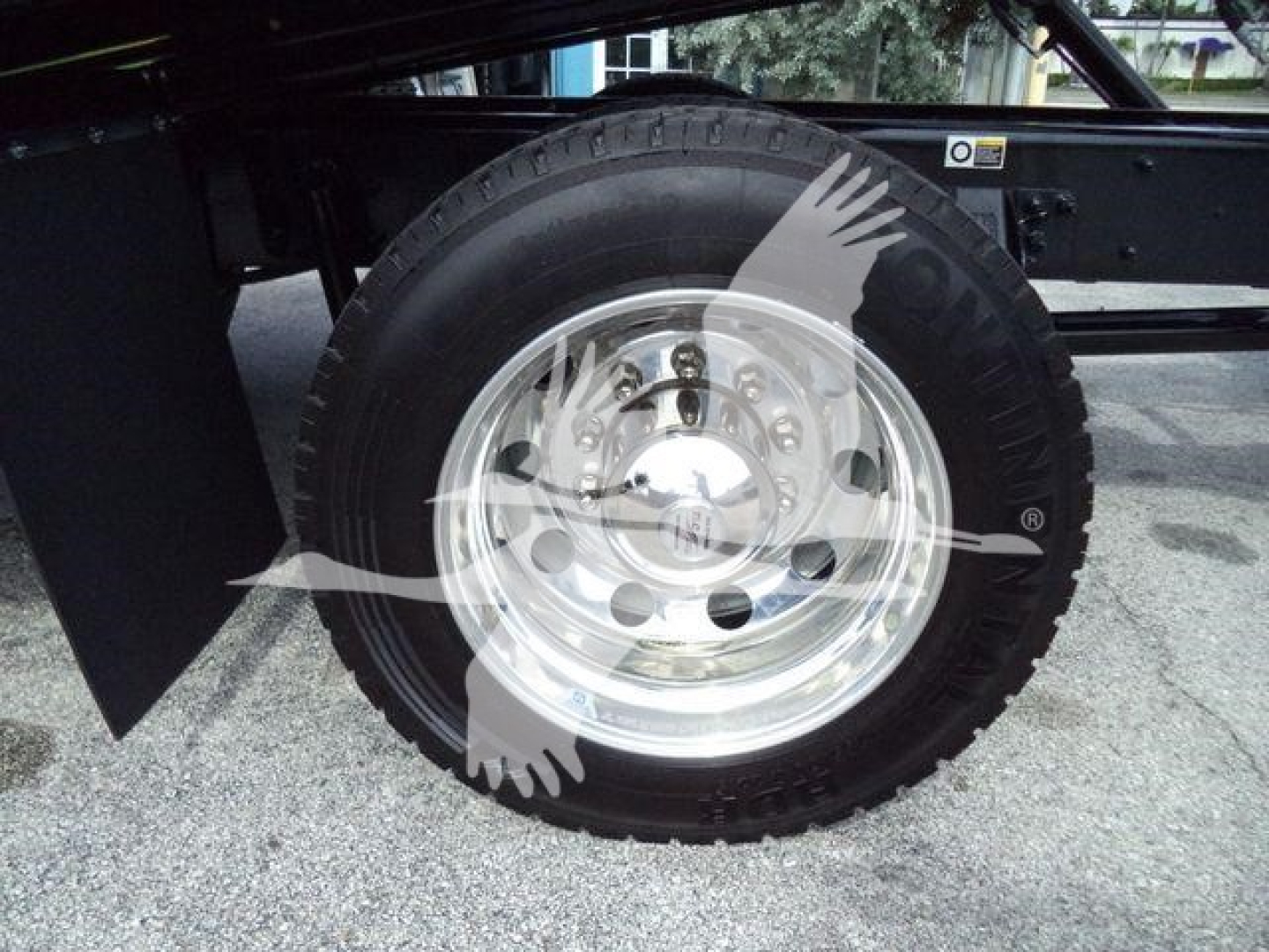 Wheel and tire on Kenworth T280 rollback chassis showing polished steel rim and black tire