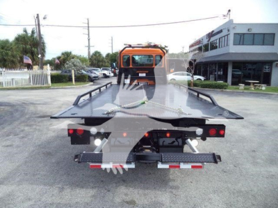 Kenworth T280 rollback tow truck rear view showing flatbed with rear lights and wheel lift, orange cab in background.