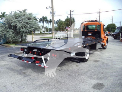 Kenworth T680? or T Series rollback tow truck rear view showing orange cab and flatbed bed with ramps