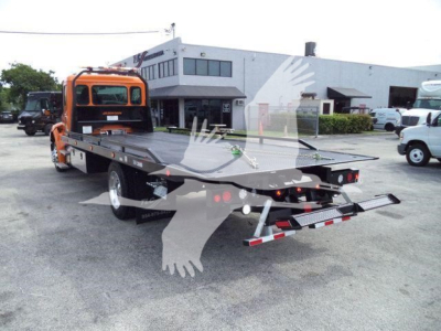 Kenworth T280 rollback tow truck with orange cab and flatbed, rear view showing loading ramp and lights.