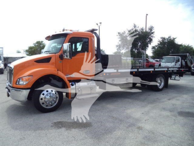 Car-hauler truck with orange cab and flatbed, Kenworth T280 model, side view showing roll-back bed and front wheel.