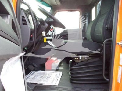 Kenworth T280 truck interior showing driver seat and dashboard with steering wheel and exposed floor; orange exterior visible at doorway.