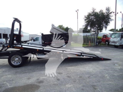 Kenworth rollback tow truck flatbed with orange accent, loading ramps extended, side view. Visible text includes 'KENWORTH' on chassis and 'ROLLBACK' on equipment.