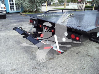 Kenworth T280 rollback truck rear view showing hydraulic ramps and flatbed platform with diamond plate surface.