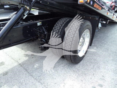 Kenworth T280 rollback truck wheel area and chassis with dual rear wheels, black frame, and part of the flatbed visible.
