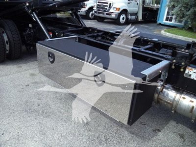 Kenworth T280 rollback chassis with a large rectangular tool/storage box mounted under the frame; chrome polished lid and black sides visible.