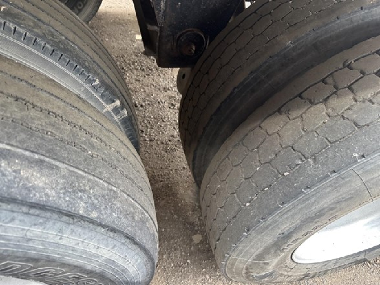 Frameless aluminum end dump trailer tires and wheels showing tread and side surfaces.