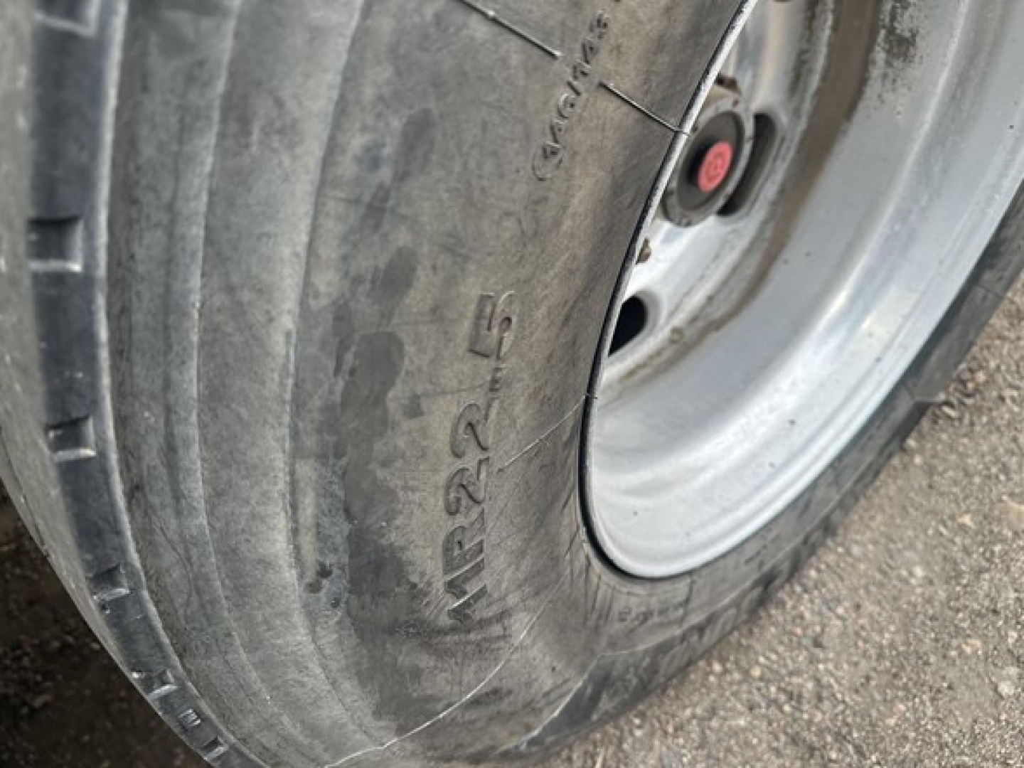 Tire and wheel of a dump trailer showing a close-up of the tire sidewall with markings.