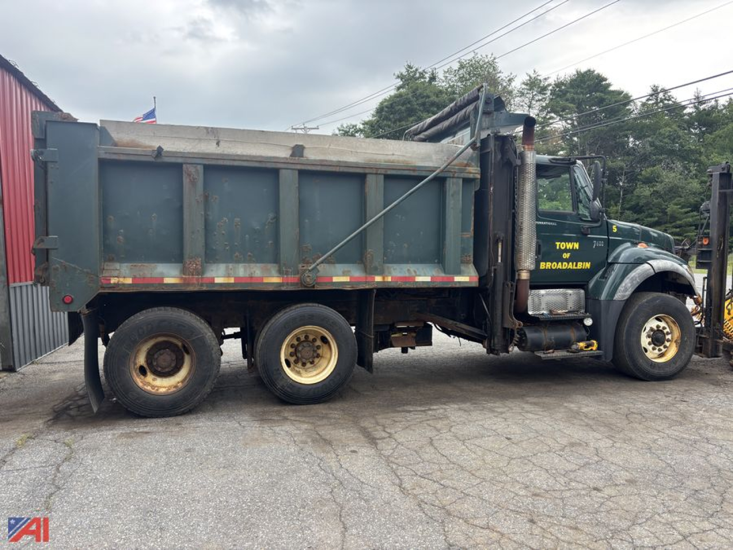 Dump truck side view showing 6x4 International WorkStar 7600 with a plow and dump bed in-service.
