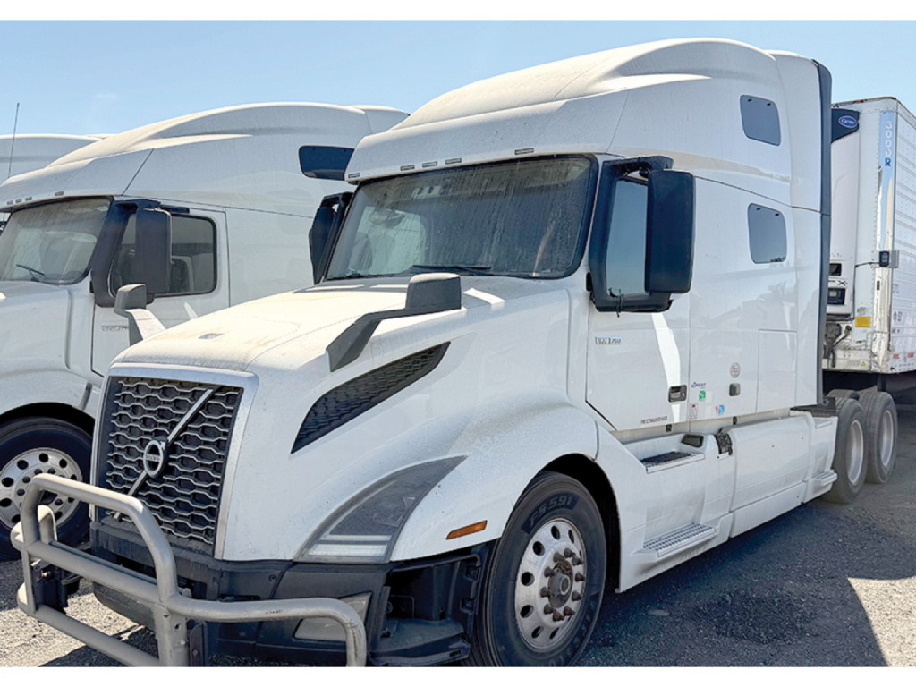 Truck: 2020 Volvo VNL 760 conventional sleeper, white with aerodynamic hood, side mirrors, and attached trailer behind. Front grille, bumper guard, and wheel hubs visible.
