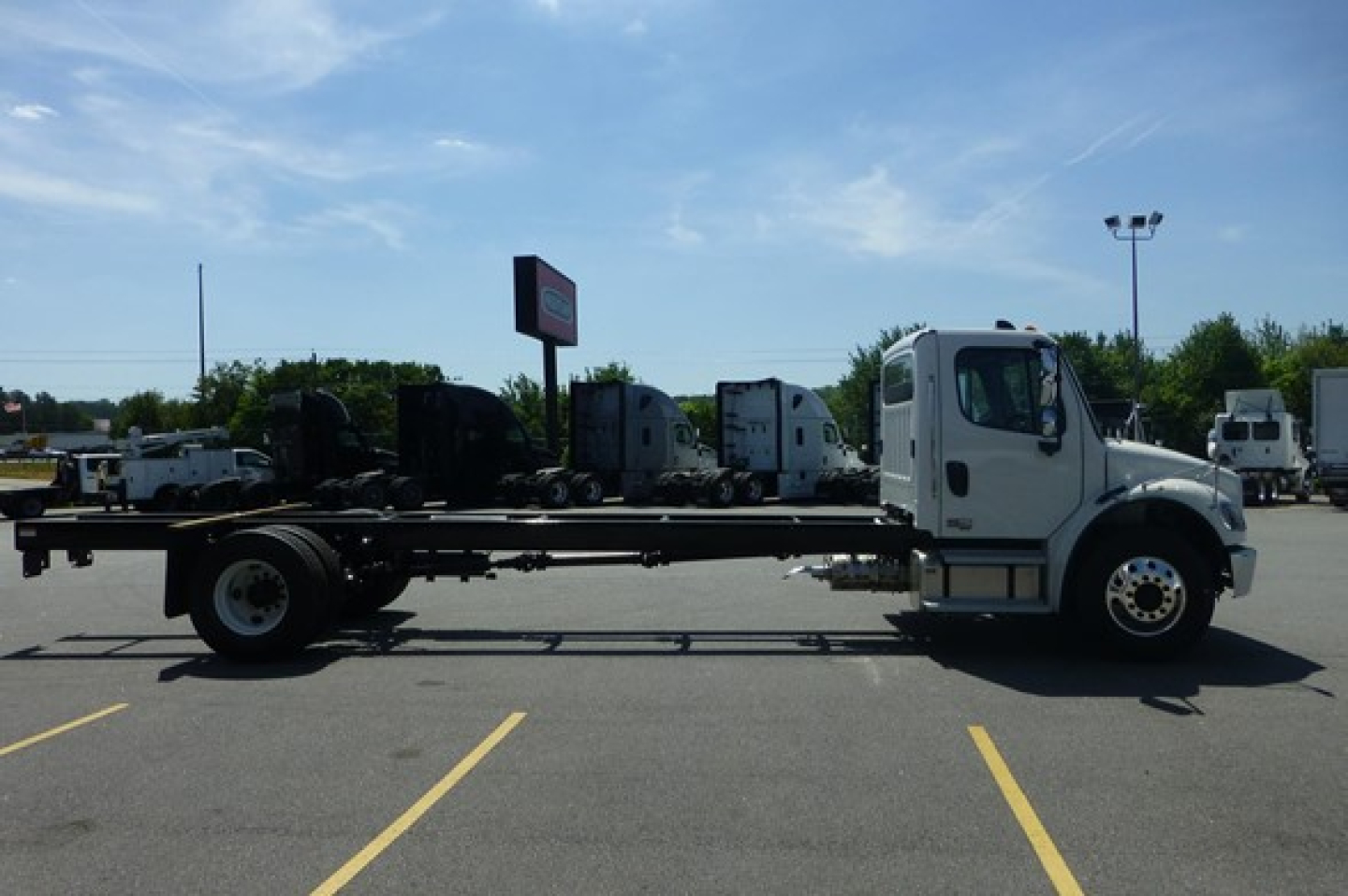 Freightliner M2 106 Plus cab chassis side view showing chassis frame and front cab with wheels.