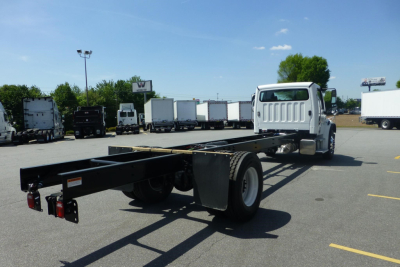 Chassis cab of a Freightliner M2 106 Plus (2027) showing the black frame rail and rear dual wheels with cab at front, VIN 1FVACWFC4VHWX8828 visible in listing context.