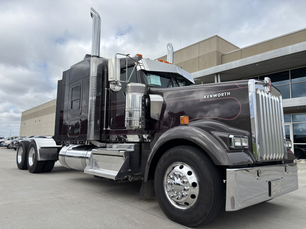 Kenworth W900L conventional sleeper truck showing chrome exhaust stacks and grille with ‘KENWORTH’ script.