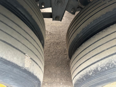 Great Dane roll door reefer trailer axles with dual tires and wheel wells, side view showing exterior tread and light dust accumulation.