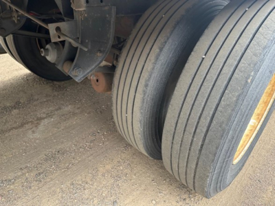Great Dane roll door reefer trailer wheel and dual tandem axle area with tires, undercarriage, and frame. 