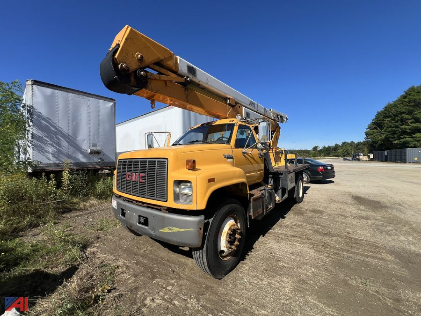 GMC C7500 bucket truck in-service showing mounted boom lift and front grille with GMC emblem.
