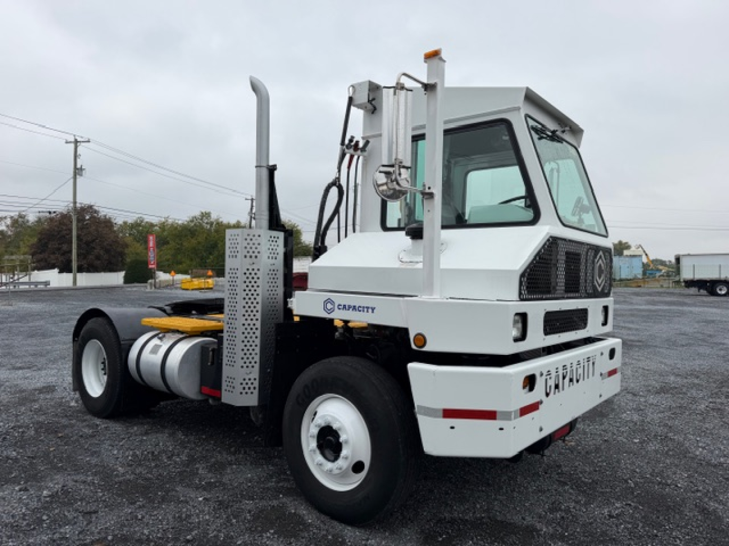 Capacity TJ5000 DOT truck chassis showing side exhaust stack, fuel tanks, and labeled control panels.