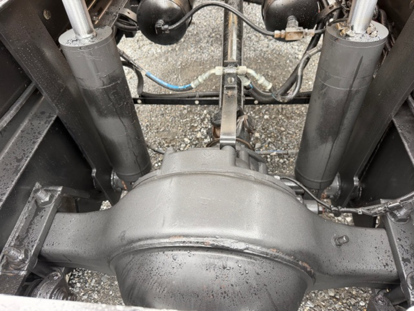 Rear view of a Capacity TJ5000 truck axle housing and suspension components with shocks and brake lines visible.