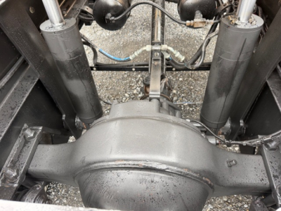 Rear view of a Capacity TJ5000 truck axle housing and suspension components with shocks and brake lines visible.