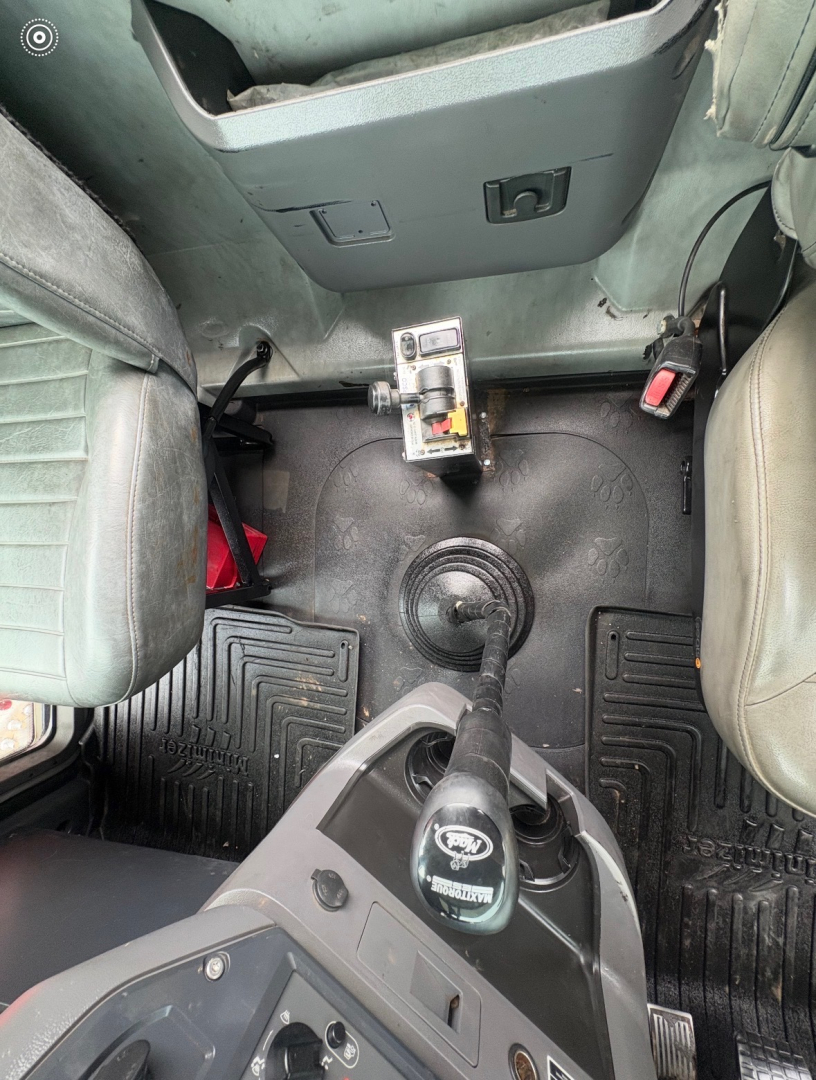 Interior view of a 2016 Mack CHU613 cab showing floor, center console, and seating with a gear shifter and accelerator pedal.