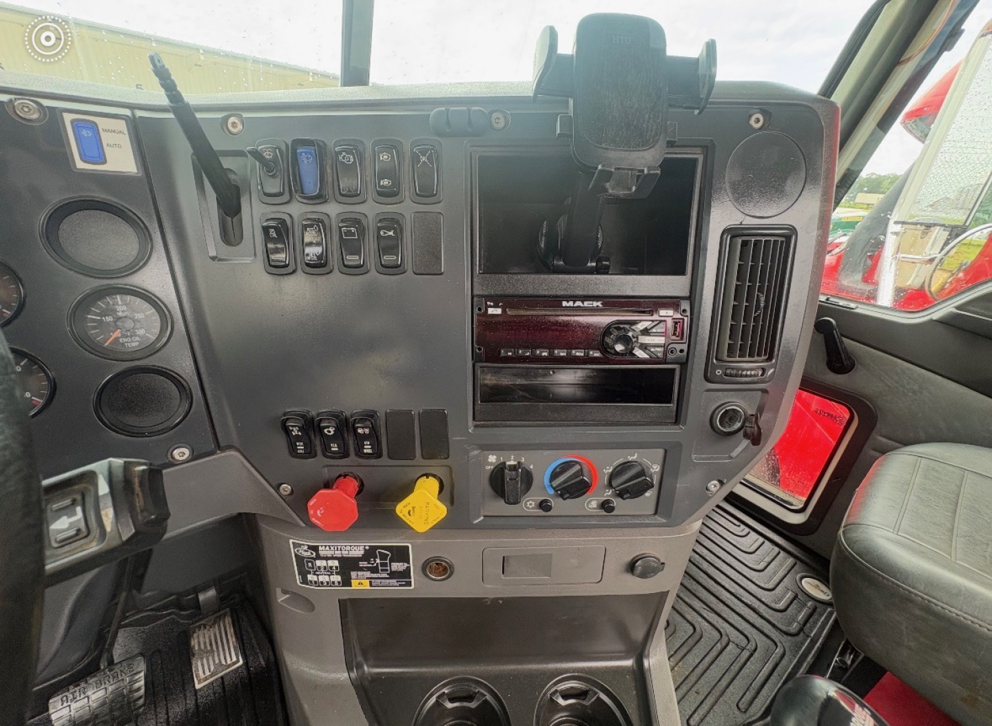 Dashboard of a 2016 Mack CHU613 truck interior showing control switches, air vent, cup holder, and gear/shifter area. Text visible includes switches and labels but not fully legible.