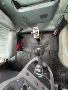 Interior view of a 2016 Mack CHU613 cab showing floor, center console, and seating with a gear shifter and accelerator pedal.
