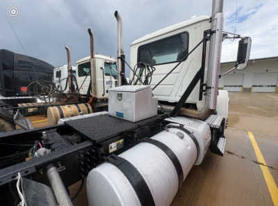 Truck chassis of a 2016 Mack CHU613 daycab showing fuel tank and exhaust stacks with cab in background.