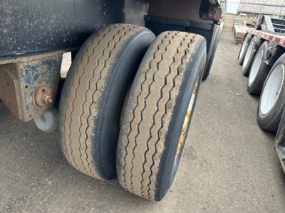 Trailer dual rear wheels showing tires and part of chassis of a 2015 Utility 4000AE flatbed trailer.