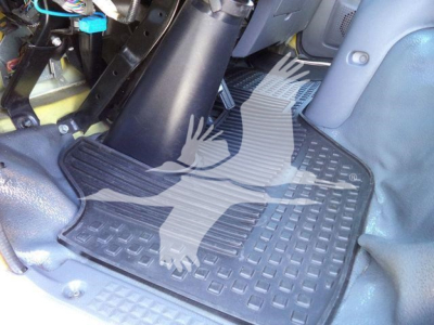 Isuzu NPR HD cab interior showing floor mat and steering area with wiring harness and dashboard edge visible.