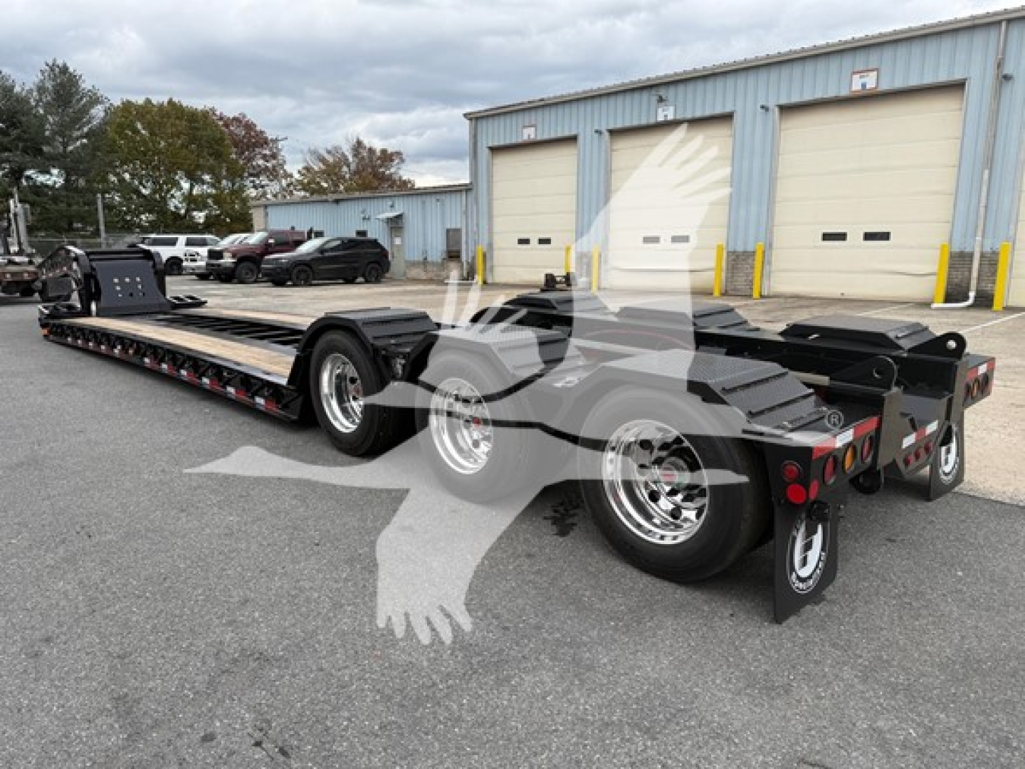  Fontaine 55Lcc lowboy trailer in an outdoor lot with dual tandem axles and long metal deck showing rear ramps and wheel areas.