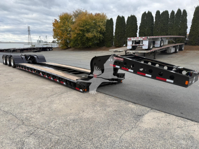 Trailer chassis and long lowboy deck showing Fontaine 55Lcc W trailer with black steel frame and multiple axles.