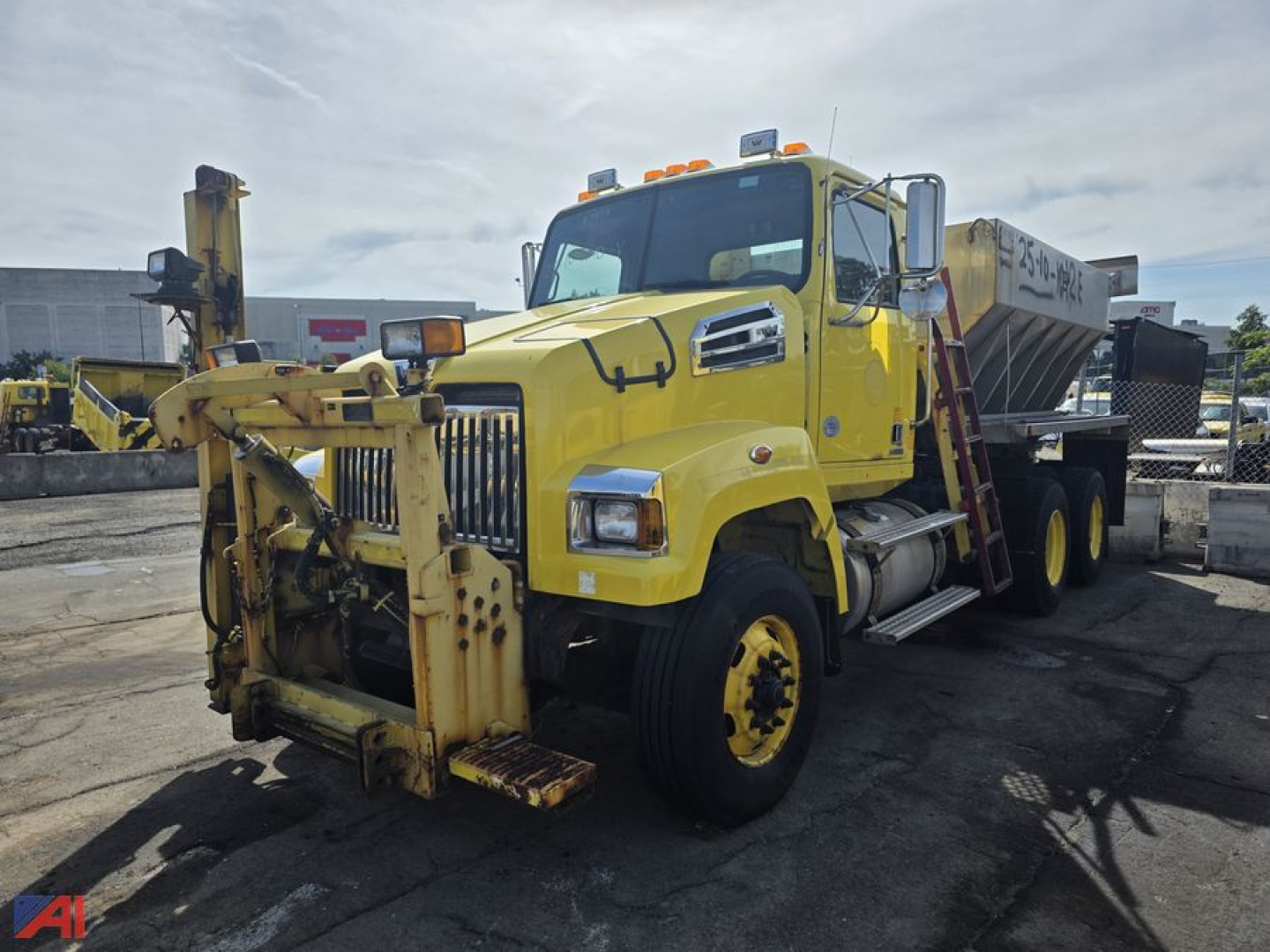 Yellow Western Star 4700 SF truck with wing and front plow attachment, side mirrors, and dump bed visible in an outdoor lot.