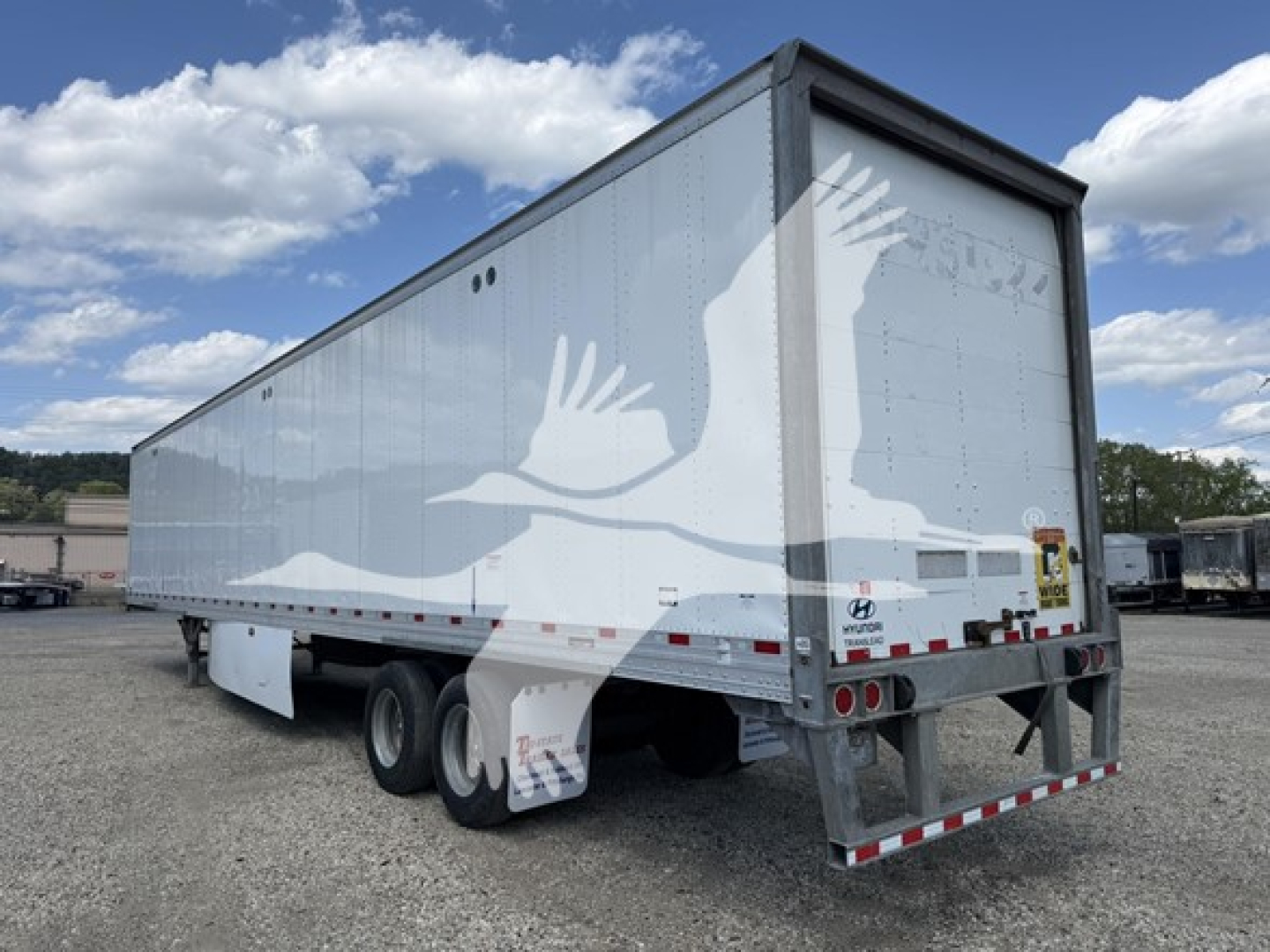 Hyundai roll door trailer/van showing side and rear, silver exterior, dual rear axles, rear bumper with hitch and taillights.