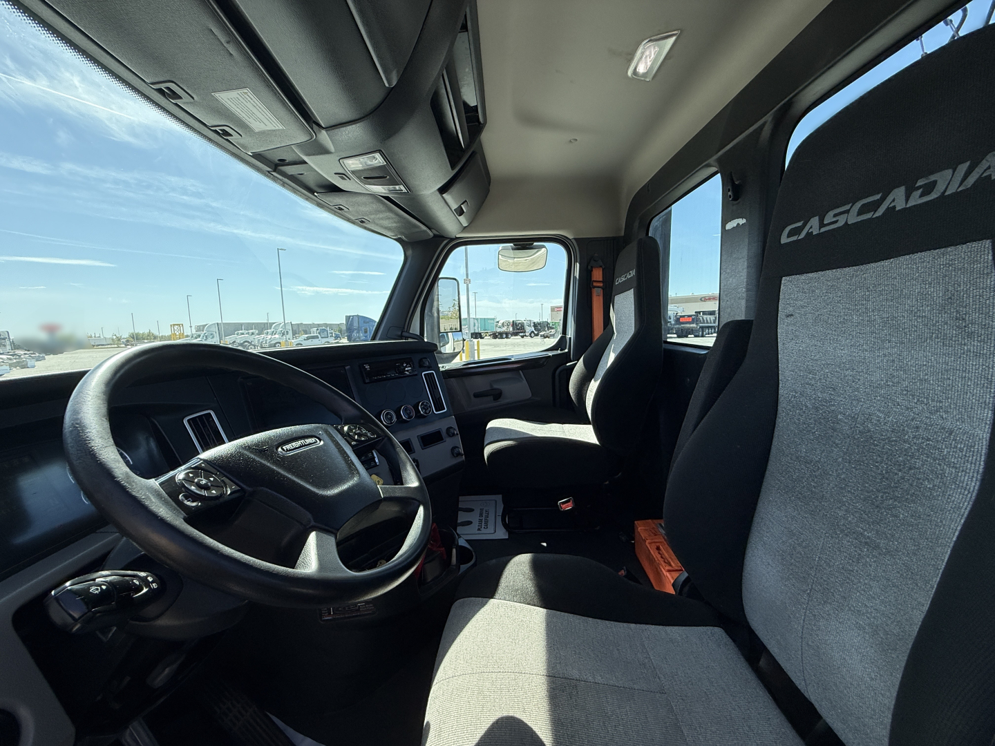 Truck cab interior showing steering wheel, dashboard, and two Crescadia seats with Casadial logos.