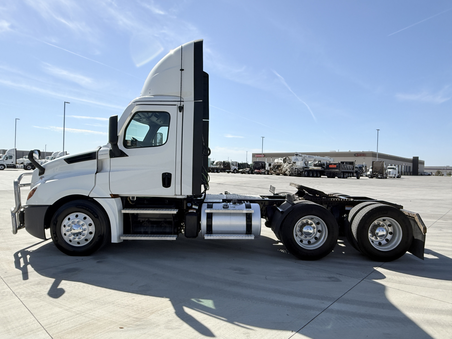 Freightliner PT126064S T conventional daycab truck side view showing cab and chassis with sleeper height behind, fuel tanks, and dual rear axles.