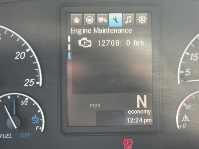 Dashboard display showing Engine Maintenance screen with 12708:0 hrs, N gear, economy, and time 12:24 pm; left and right gauges visible.