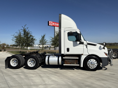 Truck side view showing 2021 Freightliner PT126064S Daycab with white cab and multiple rear axles.