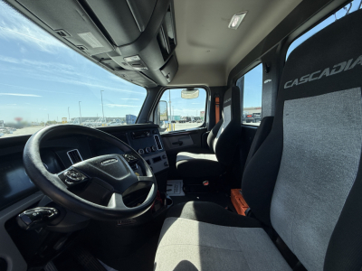 Truck cab interior showing steering wheel, dashboard, and two Crescadia seats with Casadial logos.