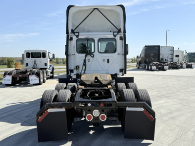 Truck rear view showing tractor cab and fifth wheel with dual rear axles and mudflaps.