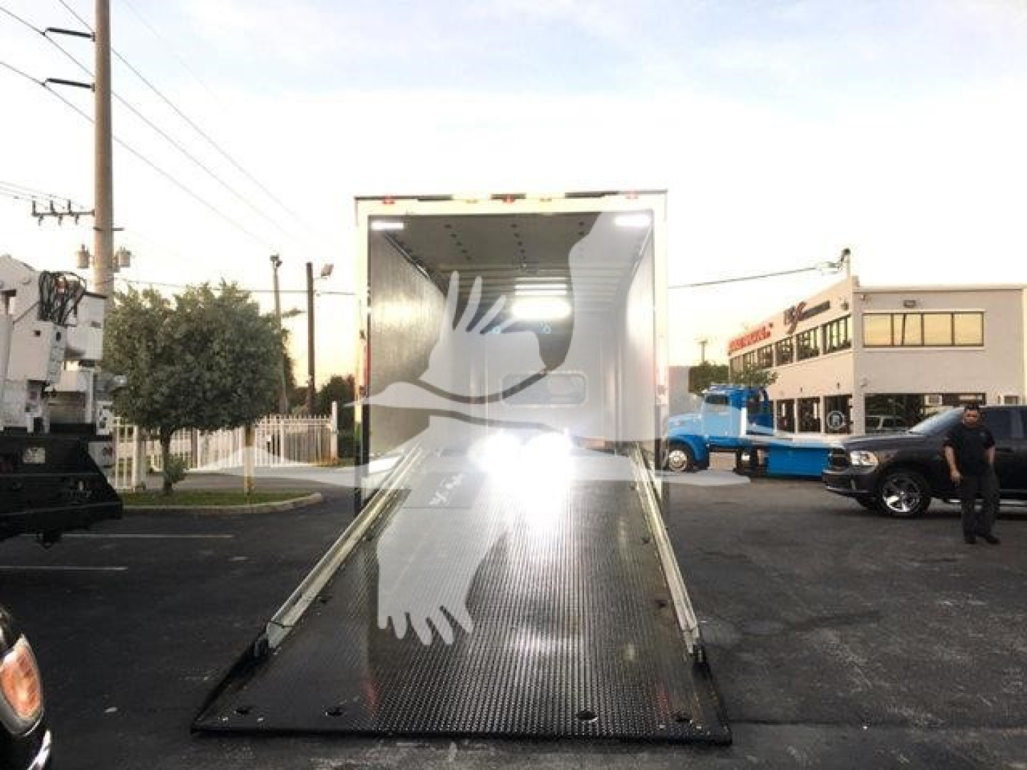 Truck trailer with an open rear ramp, loading dock area, Peterbilt 337 listing context in background.