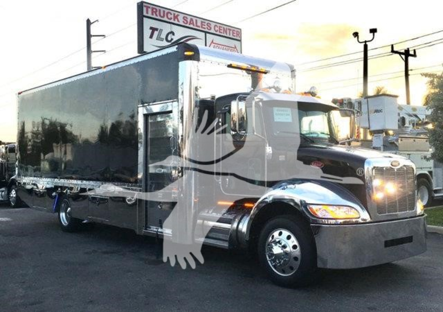 Peterbilt 337 truck with a large chrome front bumper and wrapped trailer in showroom/lot setting.