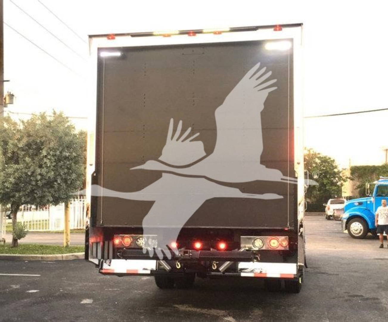 Truck back showing large white geese graphic on black rear doors, with taillights and bumper visible.