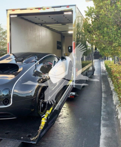 2022 Peterbilt 337 truck in a rollback trailer with a sports car loaded, interior cargo space visible, stock number J56602, side of trailer open