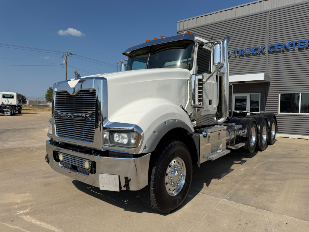 Mack TD713 Titan conventional daycab truck showing front grille and chrome bumper with triple rear axles.