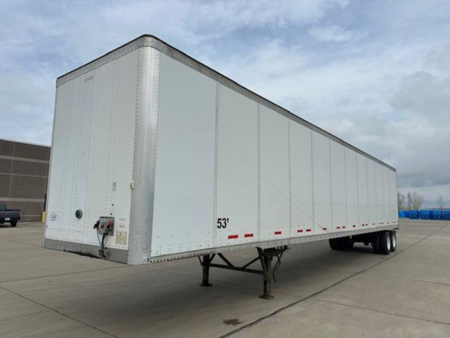 Trailer side view showing a 53' Wabash van trailer with front hitch and landing gear, aluminum exterior, DOT reflective markings.