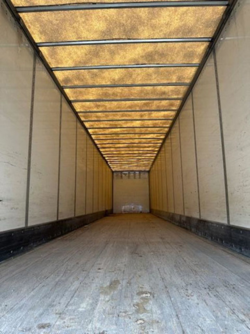 Trailer interior showing long empty Wabash van trailer with wooden ceiling panels and side walls, empty cargo floor.