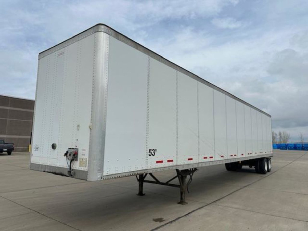 Trailer side view showing a 53' Wabash van trailer with front hitch and landing gear, aluminum exterior, DOT reflective markings.