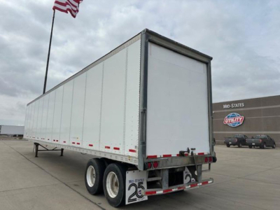 Trailer showing back and side of a 2013 Wabash van with triple-axle tandem wheels and a rear roll-up door.