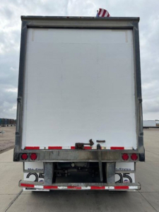 Rear view of a 2013 Wabash van trailer showing rear door, bumper, taillights, and registration hardware.